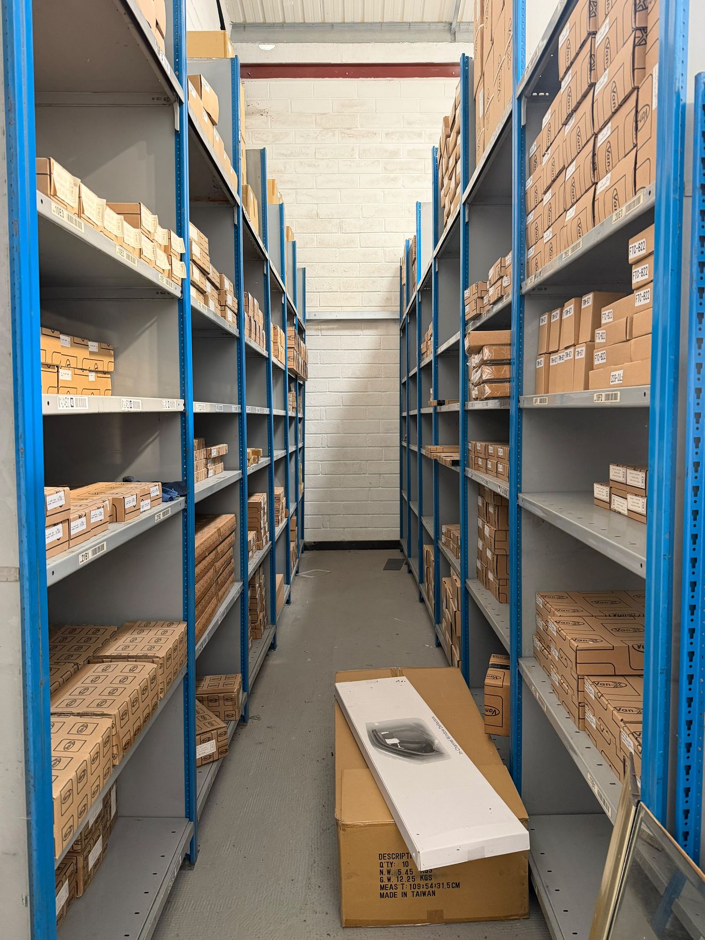 Warehouse storage aisle with blue industrial racking and stocked shelves