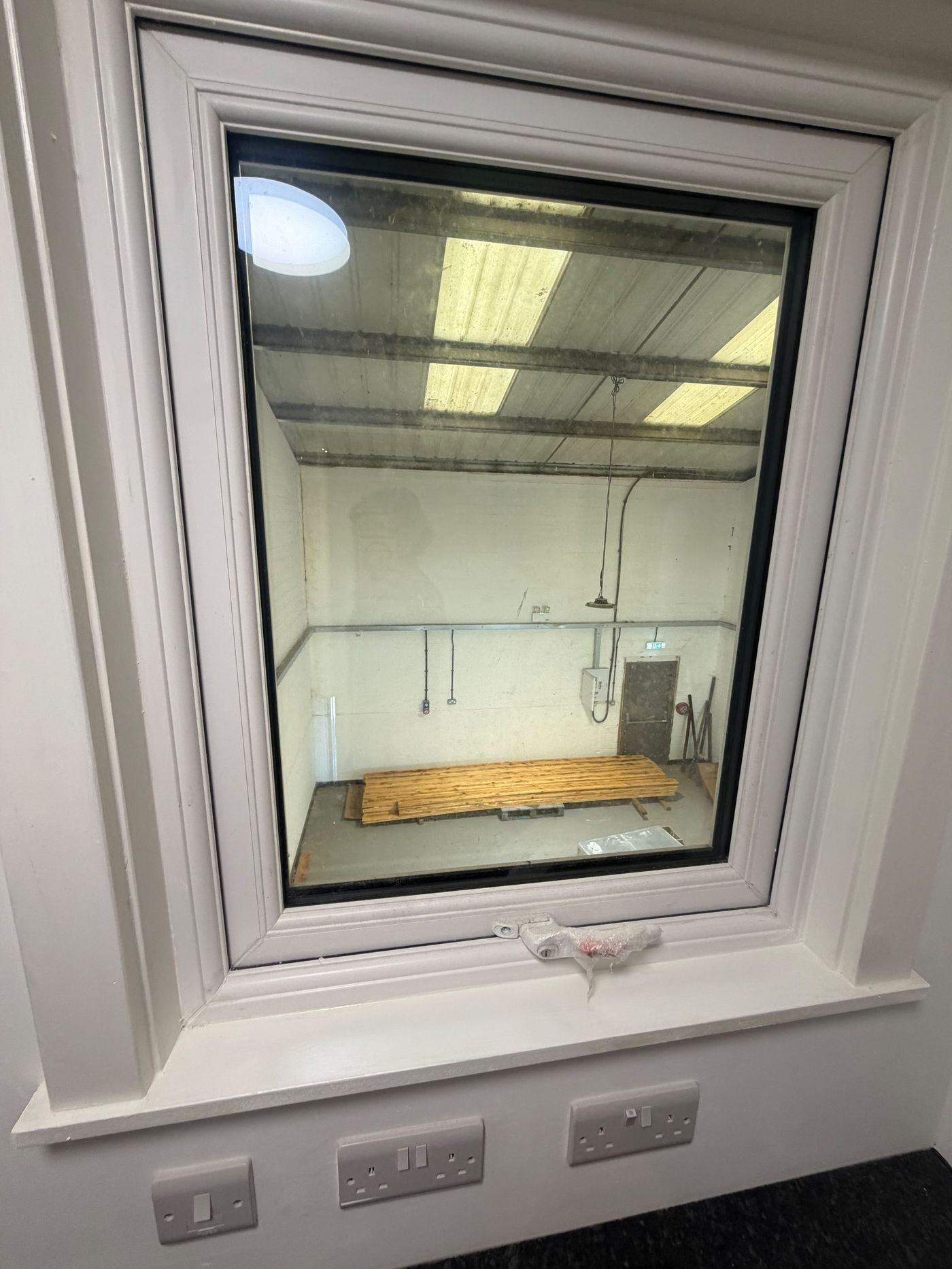 First-floor office window overlooking the ground-floor warehouse space