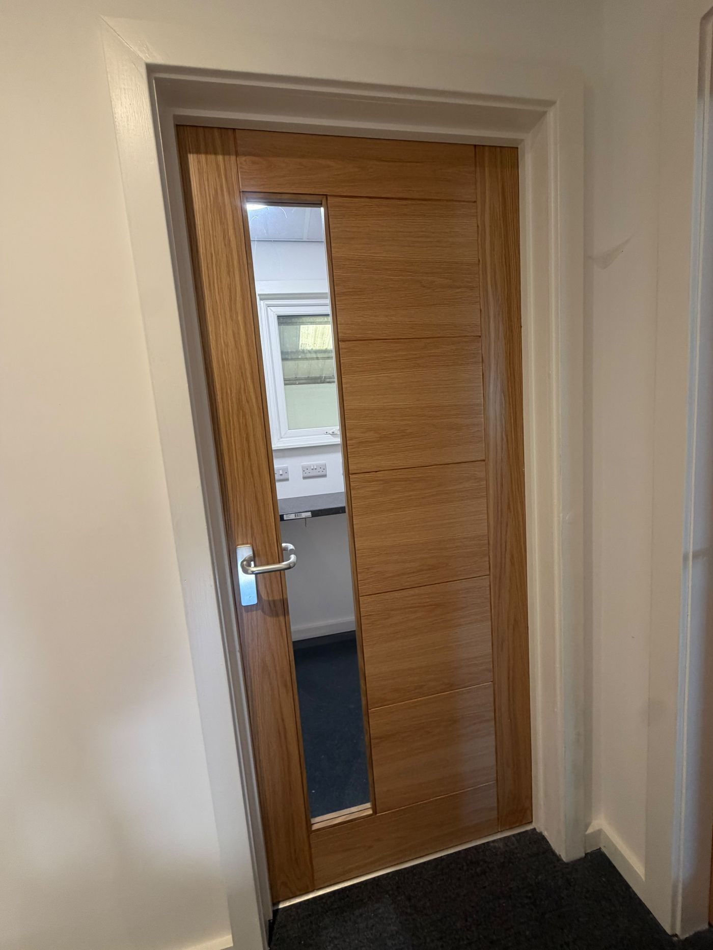 First-floor office entrance door in light oak with vision panel