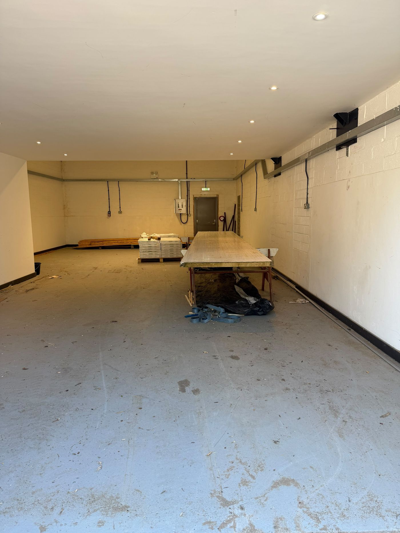 Ground-floor workshop and open warehouse space with workbench and concrete floor
